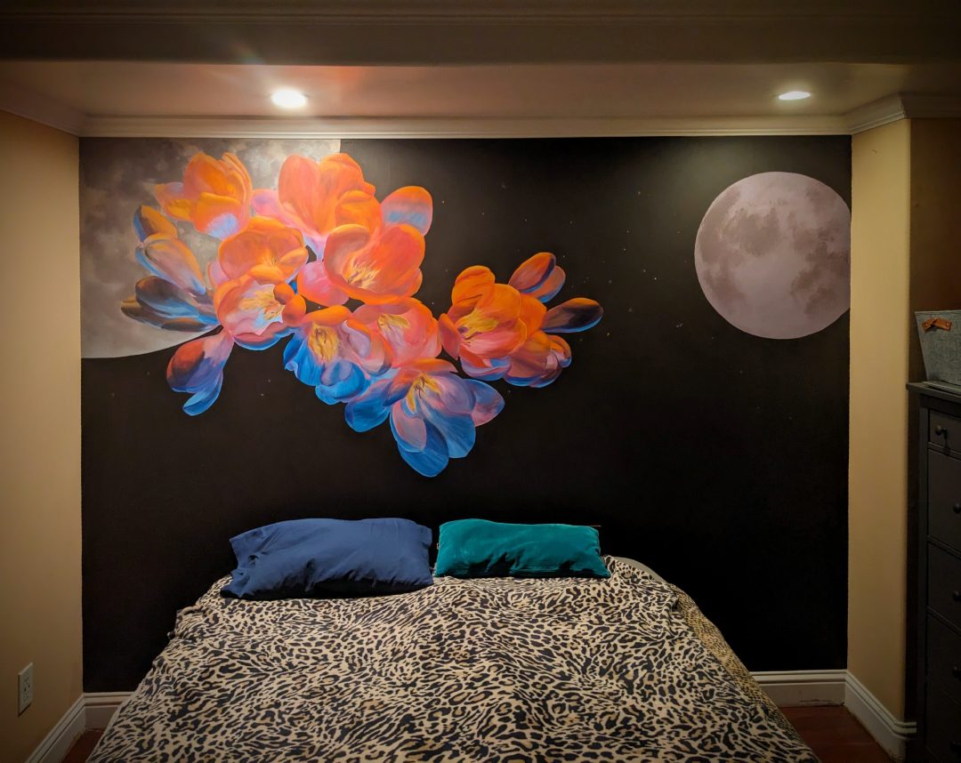 Bedroom mural of vibrant flowers over a dark starry sky with two moons.